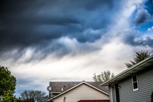 Stormy clouds over suburban house rooftops.