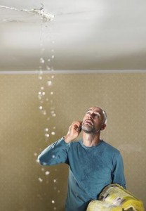 Man observing water leak from ceiling.
