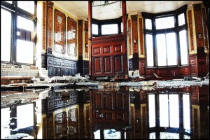 Abandoned room with water reflections and debris.